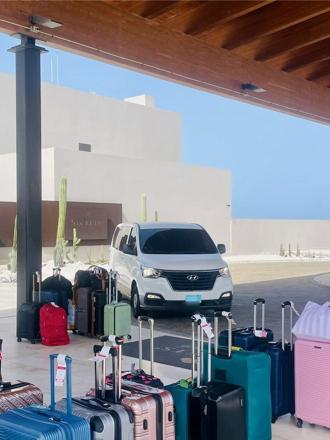 SupAce Transfers driver loading guest luggage into the Hyundai H-1 van at Secrets Baby Beach Aruba